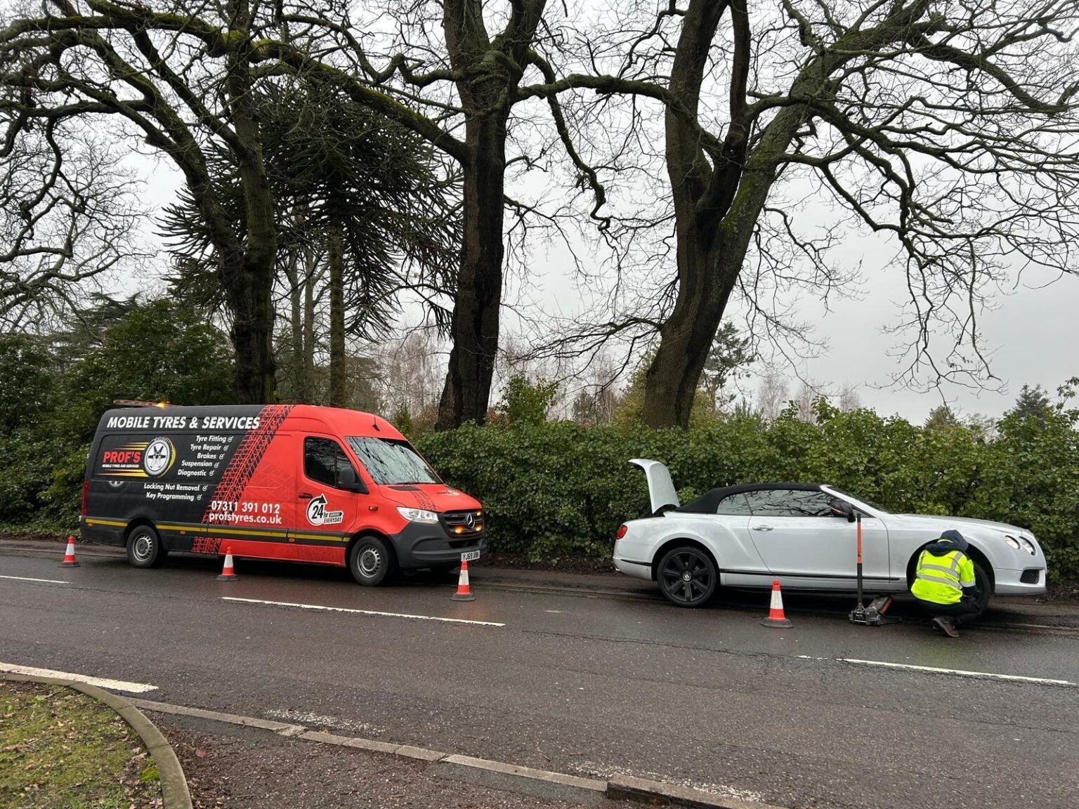 Prof’s van at the roadside while a technician changes a tyre